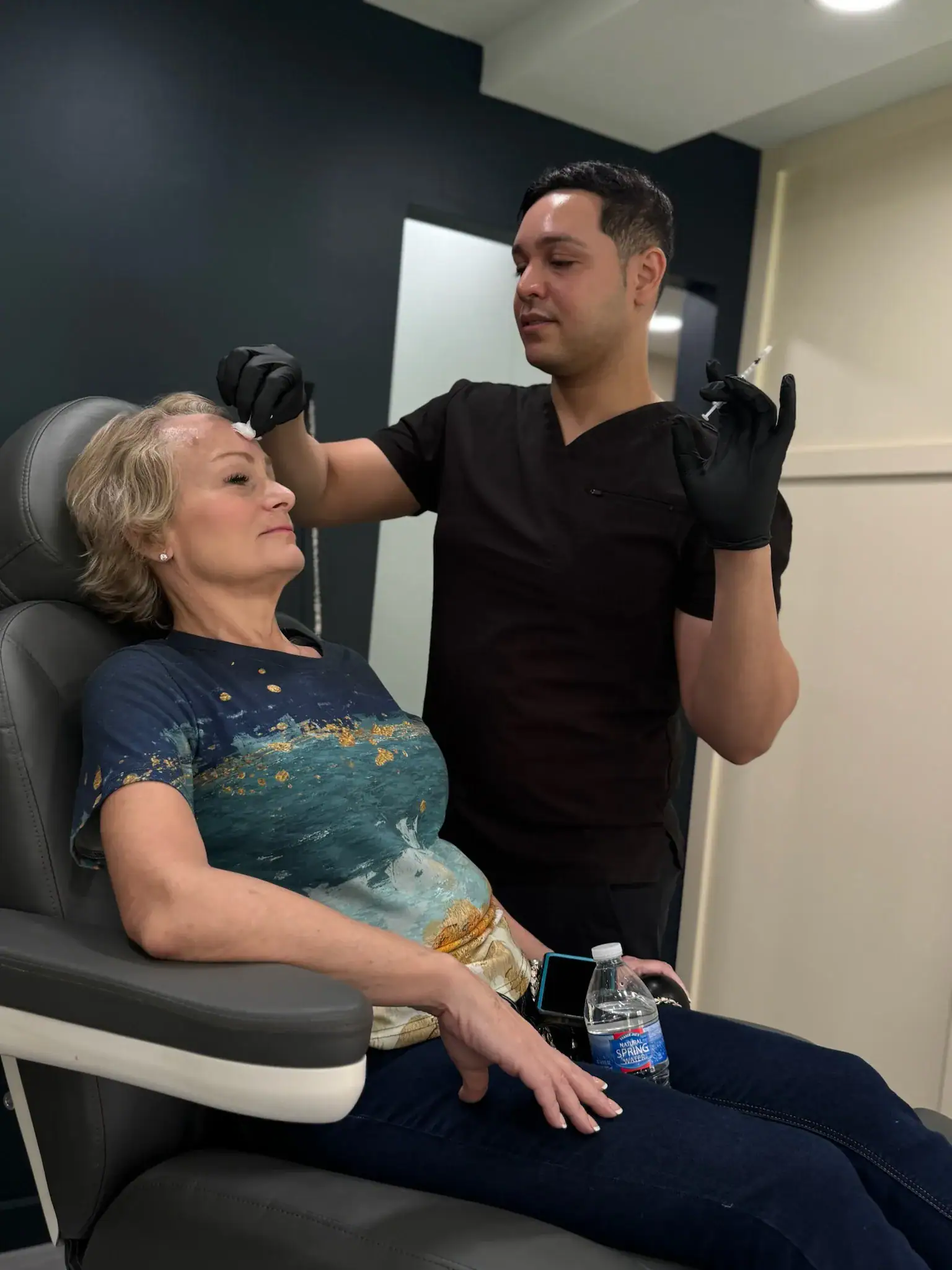 Person receiving a cosmetic injection from a professional in a clinic.