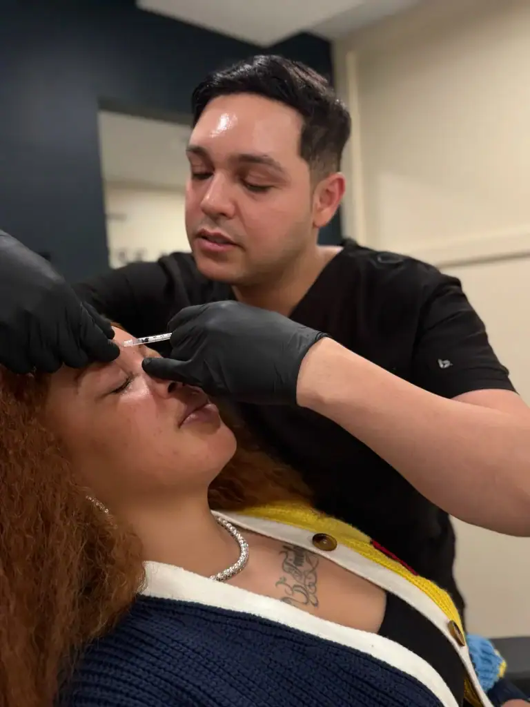 Professional administering injection during cosmetic procedure.